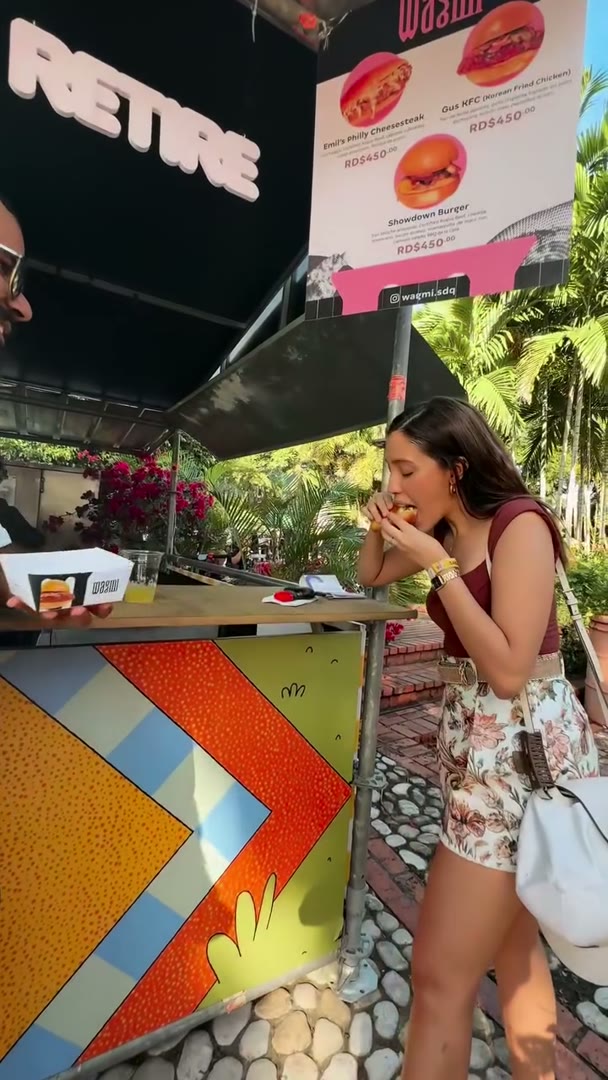 Una invitada comiendo frente al stand de WAGMI