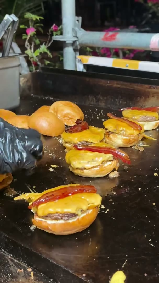 Smash burgers con queso y bacon en la plancha del stand de WAGMI