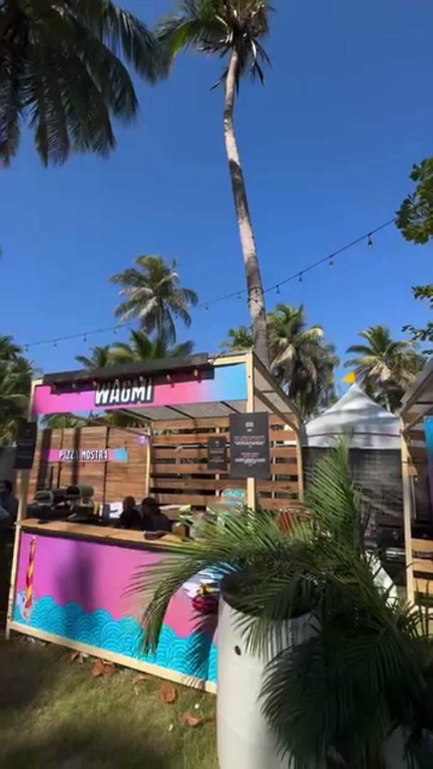 El stand de WAGMI entre palmeras en Isle of Light